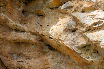the wall of a mountain canyon made of natural material, stone - limestone material of volcanic origin, close-up.