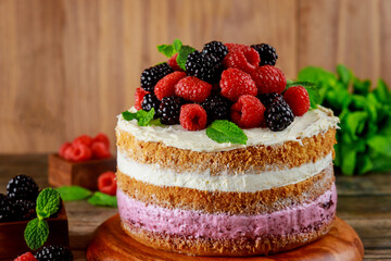 Raspberries and blackberries are decorated with homemade berry cake.