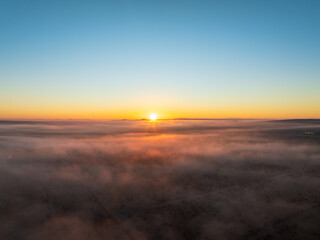 Fototapeta na wymiar Aerial Capture of a Desert’s Blanket, Where Fog and Sunset Dance in Ethereal Harmony