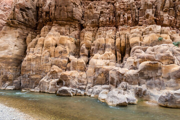 Color  diversity of mountain rocks at beginning of the tourist route in the Mujib River Canyon in...
