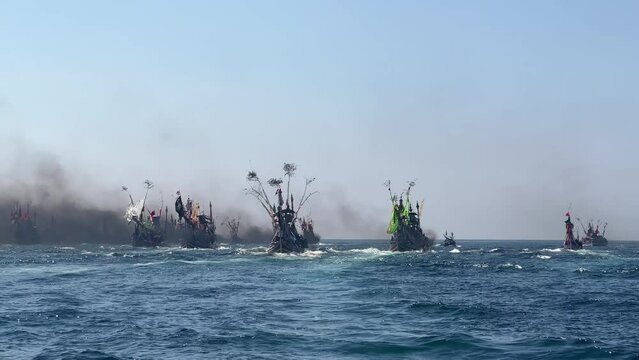 Bug number of fishing boats in Indian Ocean during Patik Laut festival in Muncar, Banyuwangi, Jawa, Indonesia covered in smoke exhaust