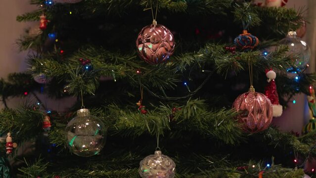 Static shot of baubles and ornaments hanging on a Christmas tree