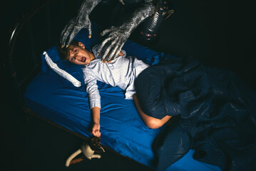 Scared boy in bed at night screaming while being attacked by a boogyman monster - obrazy, fototapety, plakaty