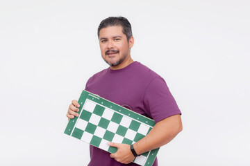 A middle aged male chess player holding a tournament sized chessboard. An avid hobbyist isolated on...