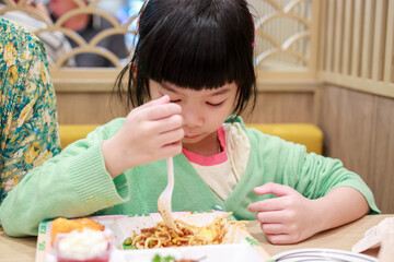 Cute little asian child girl eating food