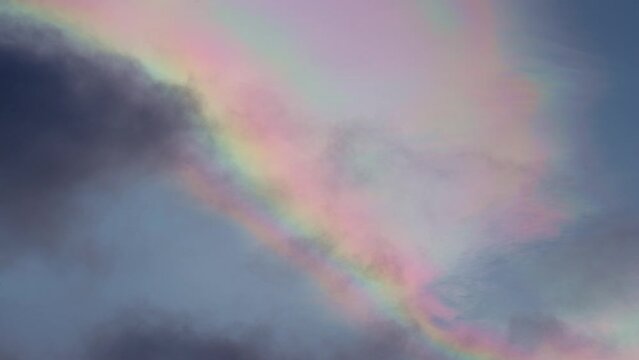 Multicolor rainbow clouds iridescence passing in the sky