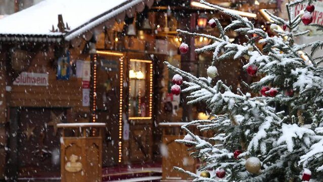 Christmas market in the snow, Christmas tree and stall selling mulled wine