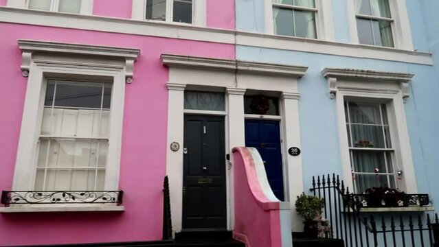 Iconic colored homes of Notting Hill in Denbingh Terrace, London. Pan right