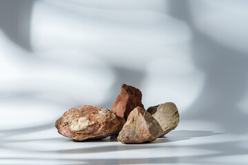 Piece of granite stone on white background with shadows