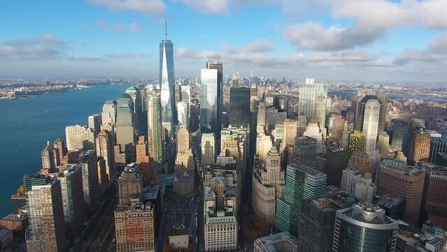 A high-flying, 4K drone shot over lower Manhattan, New York City, including the Freedom tower and the World Trade Center. The camera slowly moves backwards while facing the Freedom tower.