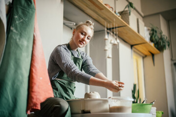 Young Woman learning pottery on a potter's wheel Creative hobby, unplugging, anti-stress