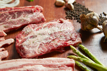 Raw meat on plate with various spices and vegetables	