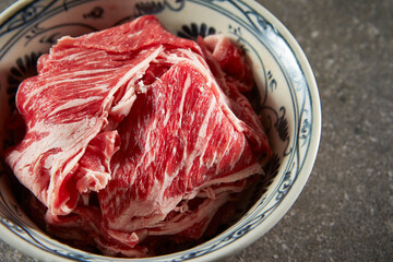 Thinly sliced raw meat in a bowl