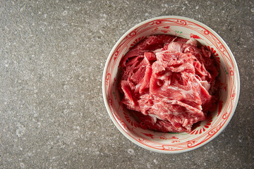 Thinly sliced raw meat in a bowl