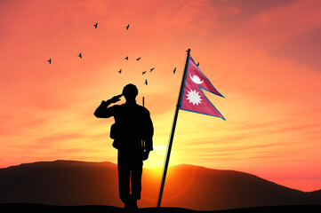 Silhouette of a soldier with the Nepal flag stands against the background of a sunset or sunrise. Concept of national holidays. Commemoration Day. - obrazy, fototapety, plakaty