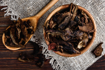 Sliced dried mushrooms on wooden background.