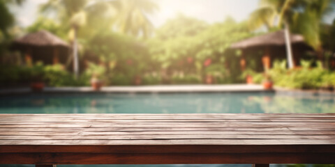 Wooden table with swimming pool in tropical restor in background