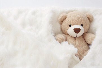 Teddy bear toy in white fur blanket