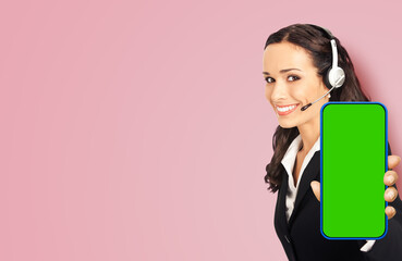 Contact support phone operator in headset show smartphone cell phone mobile green chroma key mockup screen isolated rose pink background. Consulting assistance help service call center. Caller.