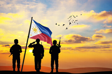 Silhouettes of soldiers with the Philippines flag stand against the background of a sunset or sunrise. Concept of national holidays. Commemoration Day. - obrazy, fototapety, plakaty