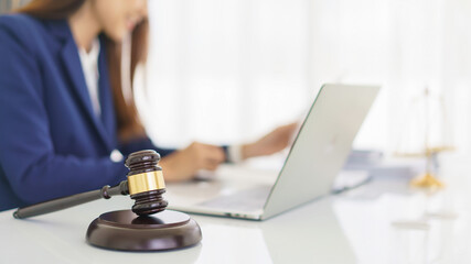 Lawyer woman reading business contract to checking legal agreement with wooden judge gavel on desk - obrazy, fototapety, plakaty