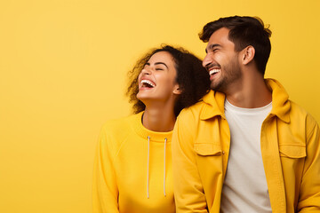 Fototapeta premium young happy couple smiling on isolated yellow background