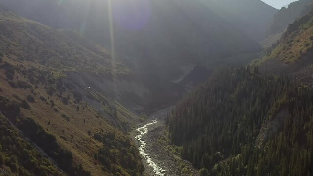 Aerial view of the Ala Archa River in the Ala Archa National Park in Kyrgyzstan. Dawn in the mountains. Green forests, hills and ridges. Active recreation in the mountains.