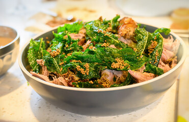 Roast lamb with mint and mustard seeds in a bowl on the kitchen benchtop. Home cooking and...