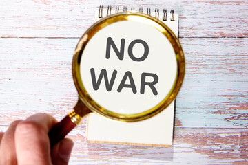NO WAR text seen through magnifying glasses on a notepad