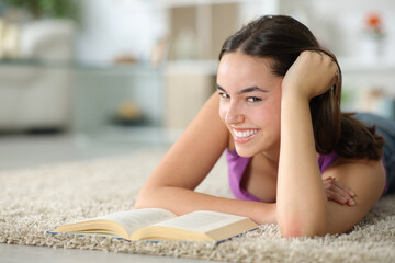 Portrait of a happy woman looking at you on the floor