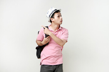 Asian man backpacker portrait with ponting finger gesture. digital nomad and travelling concept. on isolated background