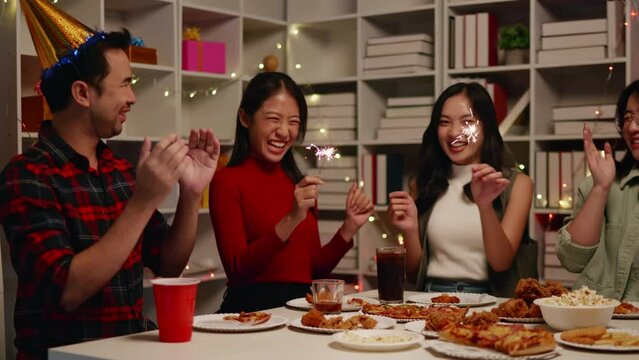 Friends play sparklers and celebrate the party with eating foods and drinks. Happy and joyful in holiday weekend and festival.