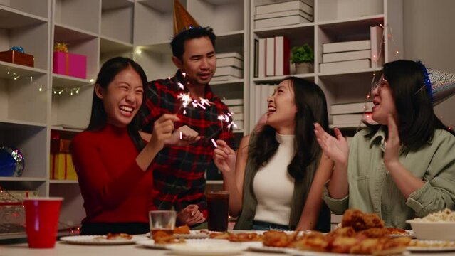 Friends play sparklers and celebrate the party with eating foods and drinks. Happy and joyful in holiday weekend and festival.