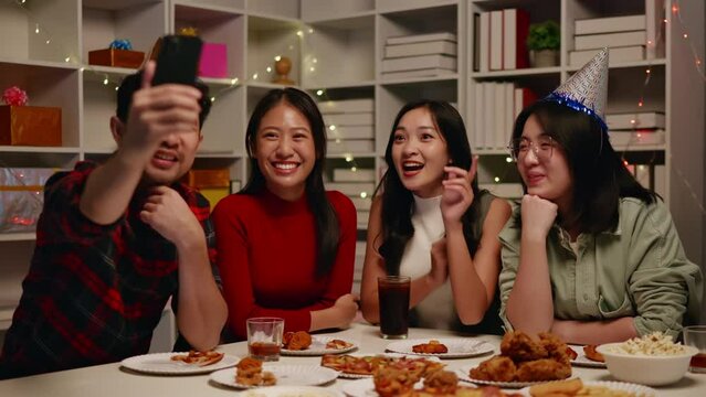 Friends use phone video call to others during celebrate the party with eating foods and drinks. Happy and joyful in holiday weekend and festival.