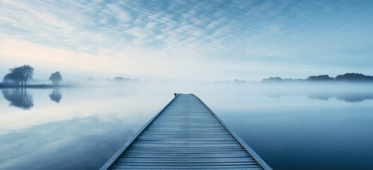 Tranquil lake scenery with mist and serene pier at dawn. Peaceful nature and meditation.