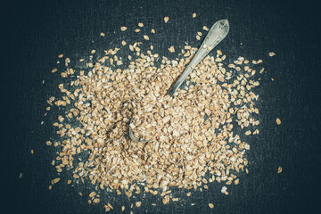 Spoon lies in a pile of tasty oatmeal on the table for good health