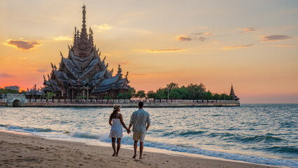A couple visit The Sanctuary of Truth wooden temple in Pattaya Thailand - obrazy, fototapety, plakaty