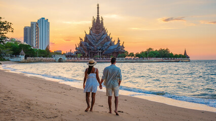 A couple visit The Sanctuary of Truth wooden temple in Pattaya Thailand