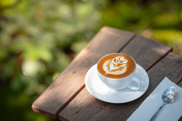 Hot art Latte Coffee. Background Coffee cup and beans on old kitchen table. 