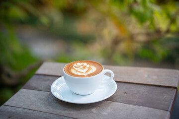 Hot art Latte Coffee. Background Coffee cup and beans on old kitchen table. 