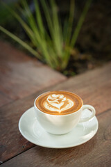 Hot art Latte Coffee. Background Coffee cup and beans on old kitchen table. 