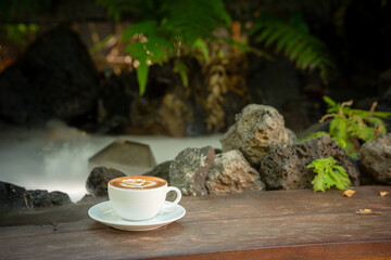 Hot art Latte Coffee. Background Coffee cup and beans on old kitchen table. 