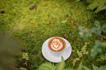 Hot art Latte Coffee. Background Coffee cup and beans on old kitchen table. 