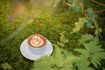 Hot art Latte Coffee. Background Coffee cup and beans on old kitchen table. 