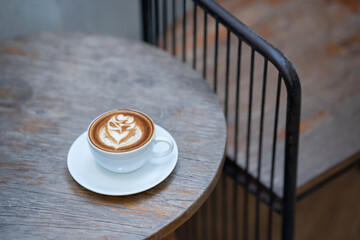 Hot art Latte Coffee. Background Coffee cup and beans on old kitchen table. 
