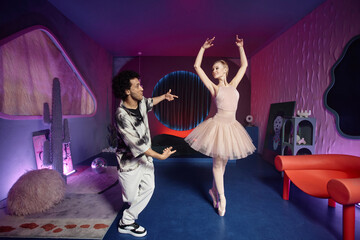 Fototapeta premium Breakdancer and ballerina demonstrating their moves on camera posing in creative art space