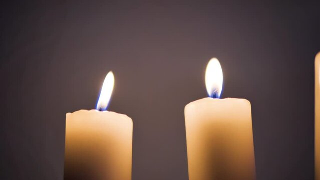 Two candles burn with a bright flame and at some point the wind blows on them and they twitch 