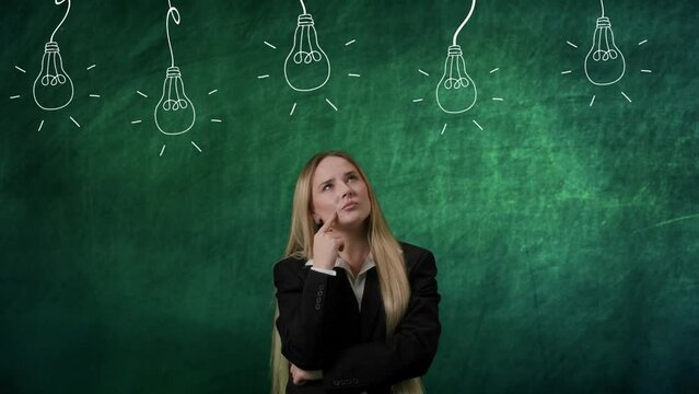 Portrait of woman isolated on green background light bulbs image on top. Girl standing thinking looks up for ideas, guessing choosing solutions, lamp lights up.