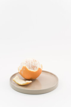immagine con primo piano di frutti di arancia su superficie bianca e piccolo vassoio