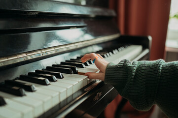 Hand of girl playing piano at home